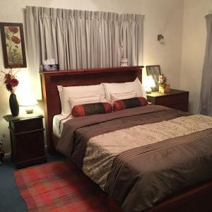 ein Schlafzimmer mit einem großen Bett und zwei Nachttischen in der Unterkunft A Cozy Room with It's Own Privacy in Upper Hutt
