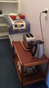 a table with a tea kettle and a toaster on it at A Cozy Room with It's Own Privacy in Upper Hutt