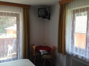 Schlafzimmer mit einem Bett, einem Tisch und einem Fenster in der Unterkunft Haus Tenk in Mittersill