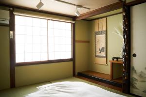 a bedroom with a bed and a large window at Nagomi TABI-NE in Kanazawa