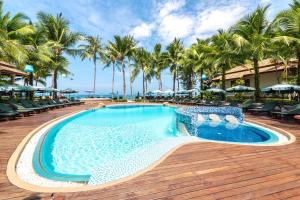 una piscina en un complejo con palmeras en Khaolak Bayfront Resort, en Khao Lak