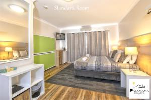 
a living room with a large bed and a large window at Panorama Jindabyne in Jindabyne
