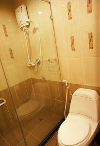 uma casa de banho com um chuveiro, um WC e um lavatório. em D Apartment em Pattaya Central