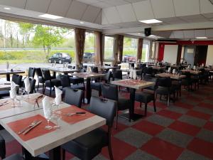 a restaurant with tables and chairs in a room at Astrotel Romorantin-Lanthenay Soirée étape in Romorantin