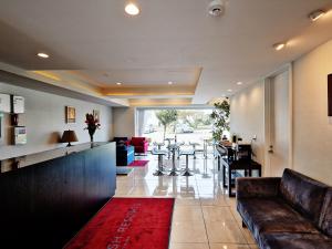 a living room with a couch and a bar at Beach Front Tower Mihama by DSH in Chatan