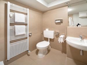 La salle de bains est pourvue de toilettes et d'un lavabo. dans l'établissement Art Hotel Aachen, à Aix-la-Chapelle