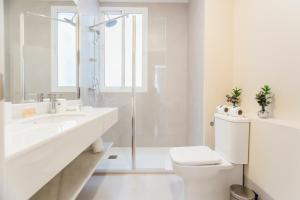 a white bathroom with a toilet and a sink at Stylish and wide- 3Bdr 3Bth- Los Remedios in Seville