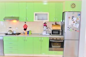 cocina con armarios verdes y nevera en Garden Cottage near Beach, Airport, en Baku 13 fotos más