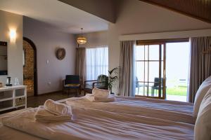 a bedroom with a large bed with a large window at Kramersdorf Guesthouse in Swakopmund
