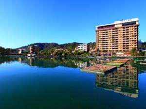 duży budynek obok dużego zbiornika wodnego w obiekcie Sun Moon Lake Hotel w mieście Yuchi