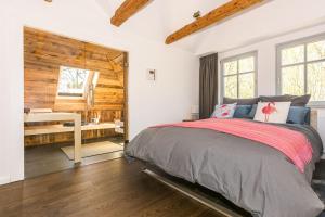 a bedroom with a bed and a wooden wall at Traumhafte Wohnung mit Sauna - 100m vom Strand in Rerik
