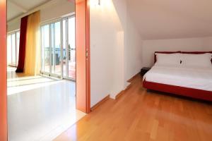 a bedroom with a bed and a large window at Apartments Amabilis in Selce