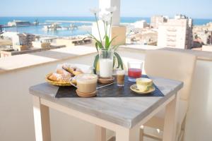 a breakfast table with coffee and pastries on a balcony at B&B Baglio Santa Croce in Porto Empedocle