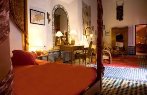 a bedroom with a bed and a dining room at Riad Al Bartal in Fez