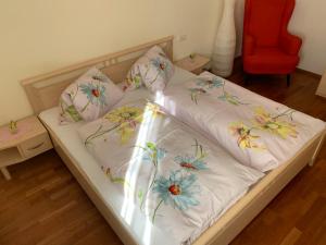 Una cama con sábanas blancas con flores. en Haus Helga, en Lienz