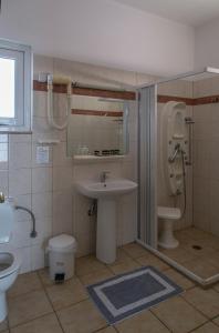 ein Bad mit einem Waschbecken und einem WC in der Unterkunft Hotel Kiani Akti in Selianitika