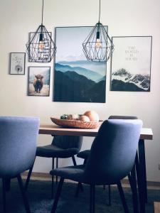 a dining room table with chairs and pictures on the wall at Wanderlust Chiemgau in Bad Endorf