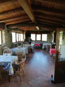 a dining room with tables and chairs and windows at Antico Borgo "Costa di Dente" in Castel dʼAiano +10 photos