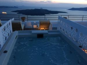 a swimming pool on the balcony of a house at Amelot Art Suites in Fira