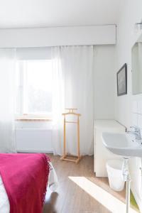 - une salle de bains blanche pourvue d'un lavabo et d'un lit dans l'établissement Hostel Buisto, à Pori 31 autres photos