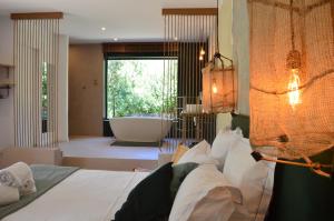 a bedroom with a large bed and a bath tub at Les Petites Maisons in Sotta +52 photos