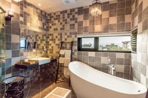 a bathroom with a tub and a sink at Rambling Snail in Luodong