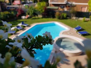 een zwembad in een tuin met stoelen ernaast bij B&B Villa Giulia in Desenzano del Garda