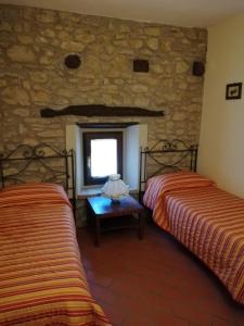 two beds in a room with a window at Antico Borgo "Costa di Dente" in Castel dʼAiano