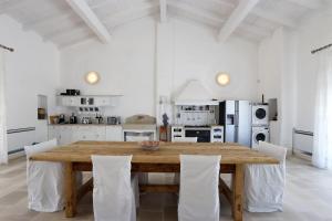 a large white kitchen with a wooden table and chairs at Masseria Fano Relais & Wine in Salve
