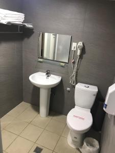 a bathroom with a toilet and a sink and a phone at 心園生活旅店 Xin Yuan Hotel in Hsinchu City