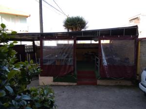 una casa con un porche con una planta en el techo en Hospedaje O Canizo, en Hío