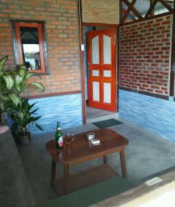a table with a bottle and two glasses on it at Salty Dog Hostel in Telukdalam