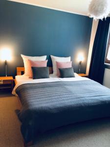 a bedroom with a large bed with blue walls at Wanderlust Chiemgau in Bad Endorf
