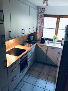 a kitchen with white cabinets and a sink and a stove at Wanderlust Chiemgau in Bad Endorf