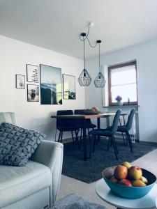 a living room with a couch and a table with a bowl of fruit at Wanderlust Chiemgau in Bad Endorf