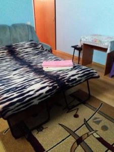 a bed with a black and white blanket on it at улица Прохоровская 12 квартира in Odesa