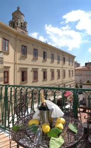 uma mesa com uma garrafa de vinho e limões numa varanda em Residenza Luce em Amalfi