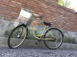 a bike with a basket parked next to a brick wall at Thipwararom homestay in Takua Pa