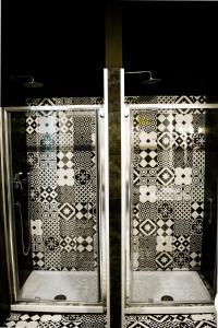una puerta de cristal de una ducha con azulejos en Hostel Trastevere, en Roma