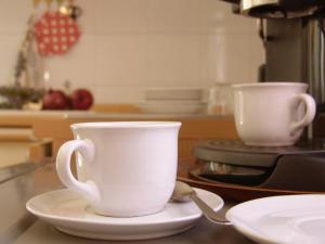レヴァントにあるAgriturismo La Quieteのキッチンのカウンターに置かれた白いコーヒーカップ2杯