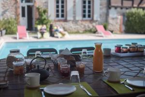 een tafel met eten en drinken naast een zwembad bij Chambres d'Hôtes Le Pignié in Lescure-dʼAlbigeois
