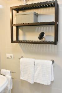 a bathroom with white towels hanging on a rack at Apartamentos Las Naranjas in Jerez de la Frontera