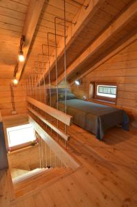 una camera con un letto in una cabina di legno di Rifugio Il Ginepro dell'Etna a Linguaglossa