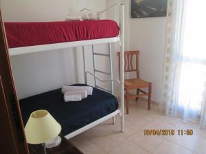 サン・ヴィート・ロ・カーポにあるCasa Nikのベッドルーム1室(二段ベッド2組、ランプ付)