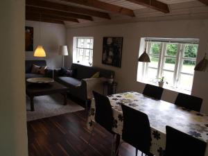 a living room with a table and a couch at Fædrelandet Ferielejlighed & Turridning in Læsø