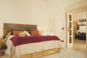 1 dormitorio con 1 cama grande con almohadas rojas en Palazzo Margherita, en Cisternino
