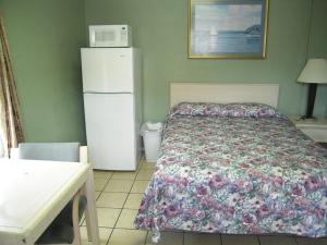 a bedroom with a bed and a white refrigerator at Bayfront Cottages in Rockport