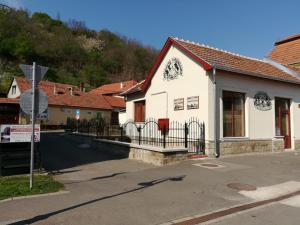 a white building with a fence in a street at Centrál Apartman in Tokaj