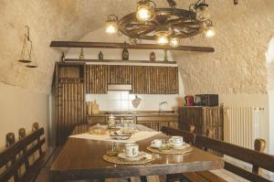 a dining room with a table and a chandelier at Palazzo Margherita in Cisternino