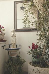 Una statua seduta su una ciotola in una stanza con delle piante. di Palazzo Margherita a Cisternino
